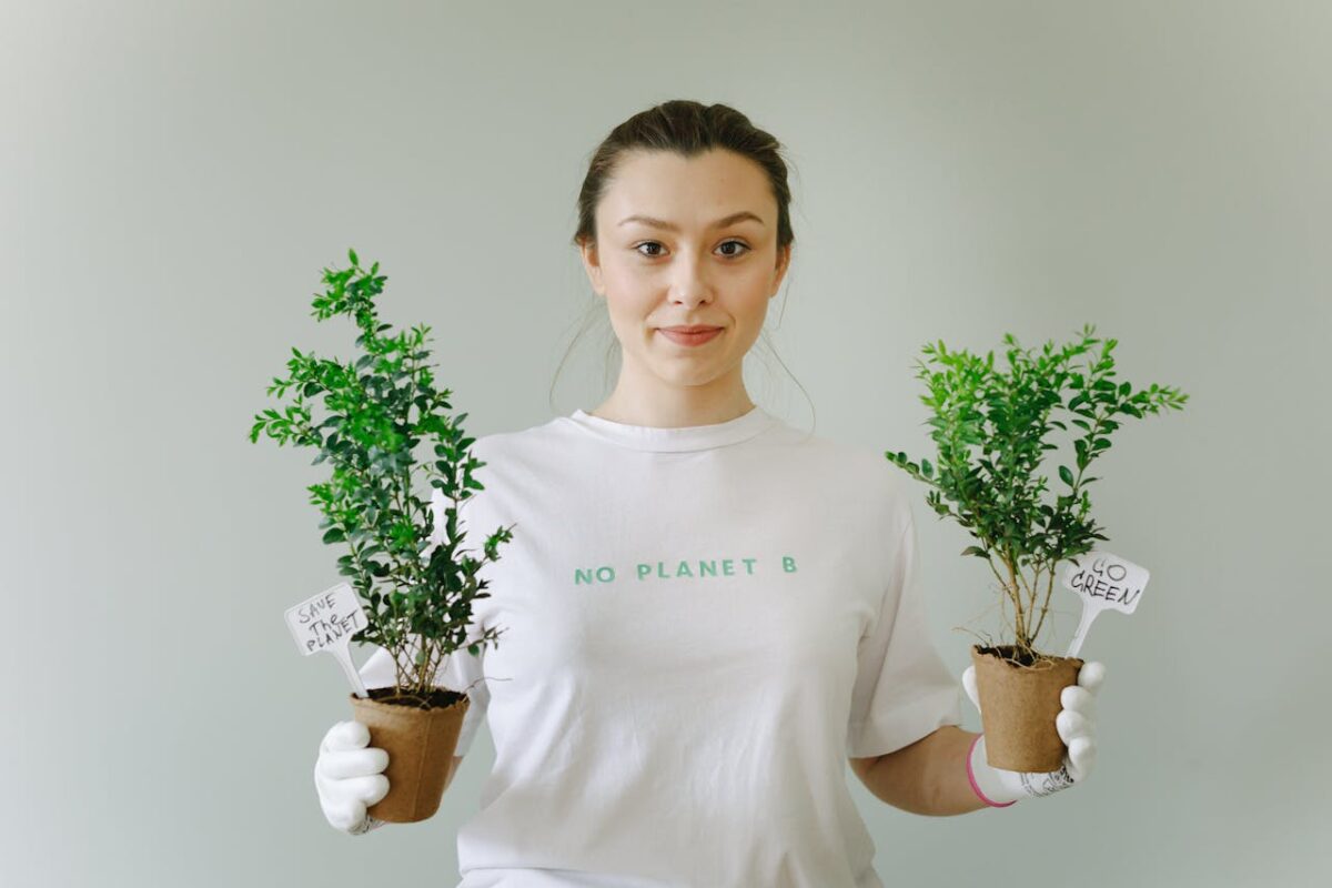 A woman holding potted plants promotes environmental awareness and going green.